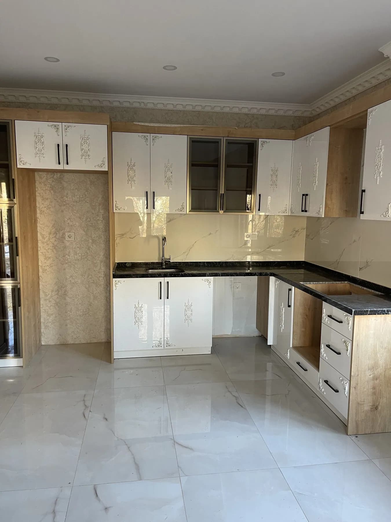 Beyaz kapaklı, ahşap detaylı, siyah tezgâhlı L mutfak